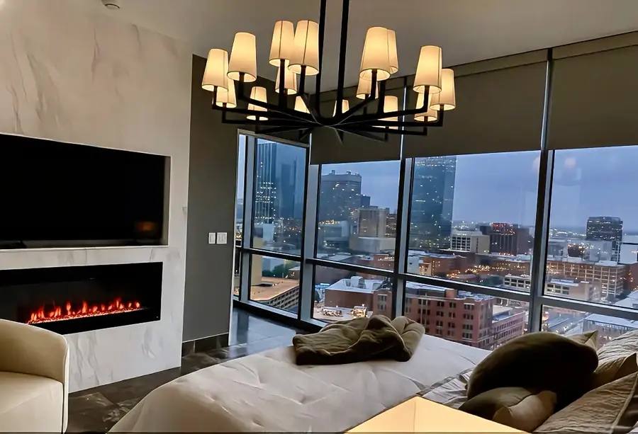 Bedroom at night with fireplace and downtown Dallas skyline