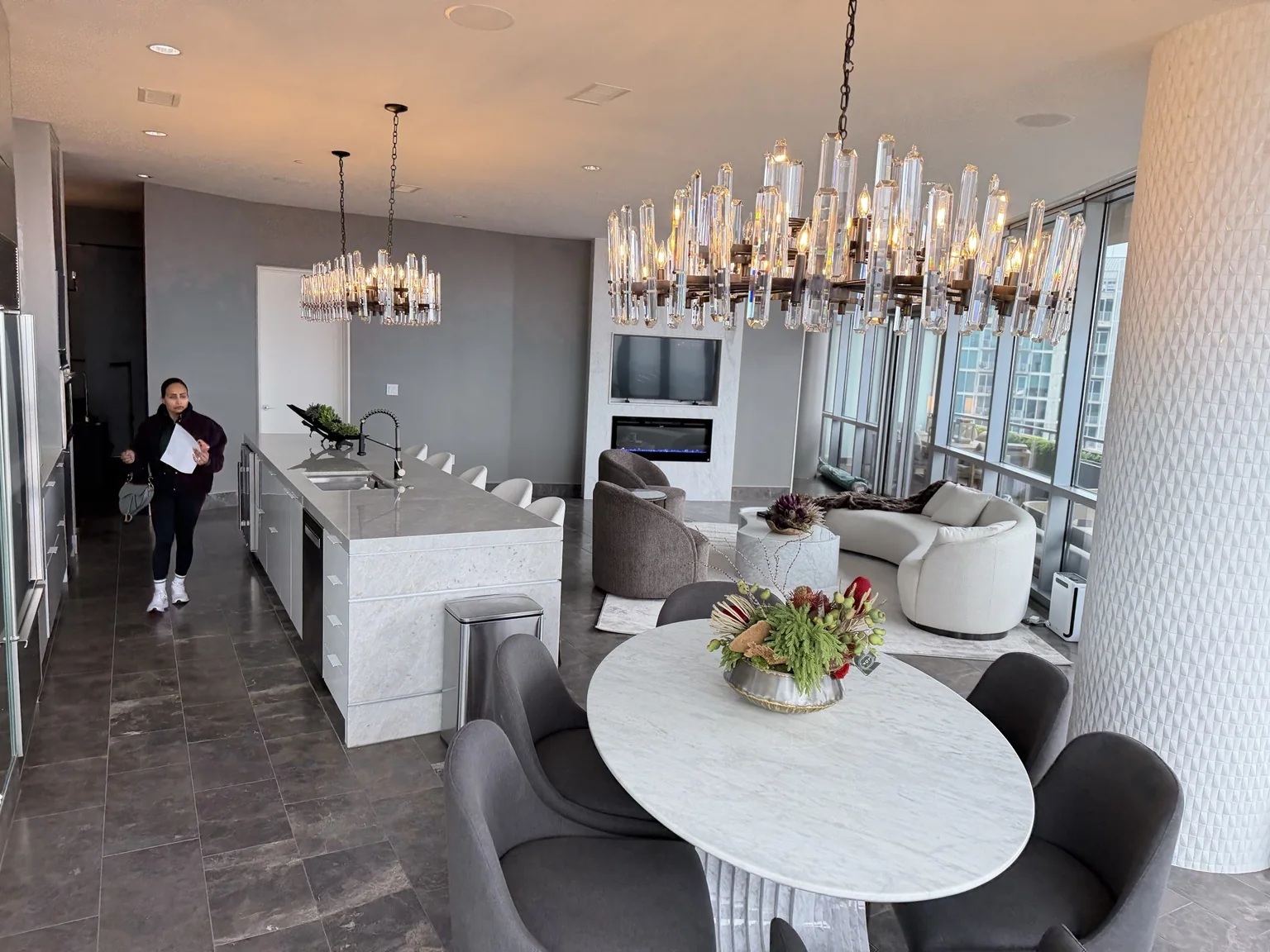 Wide view of a finished high-rise kitchen, dining and living space with crystal lighting